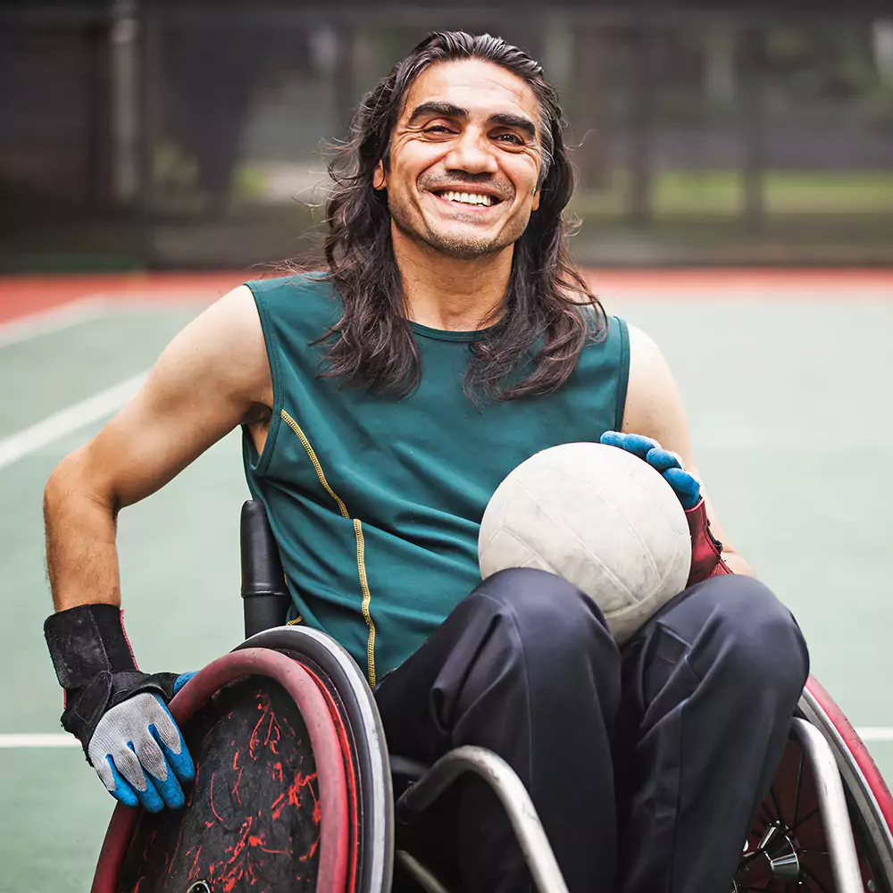A disabled man in a specialty sport wheelchair playing sports outdoors